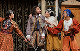 Valentine in light purple coat and colorful cavalier breeches has swords in both hands pointing down as he surrenders to the three outlaws in various ragged Jacobean clothes and masks pulled up on their foreheads.